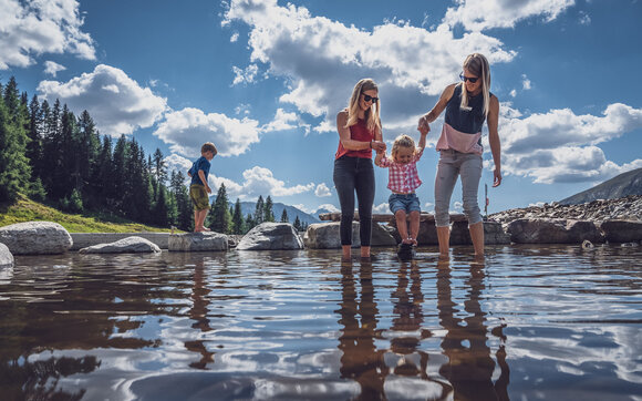 Familie kühlt Füsse ab im Bergsee  | © Davos Klosters Mountains