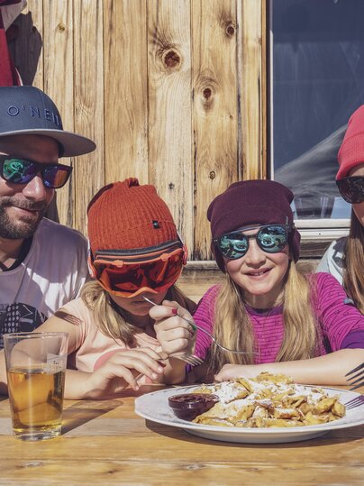 Familie teilt sich einen Kaiserschmarn in der Hubelhütte. | © Davos Klosters Mountains