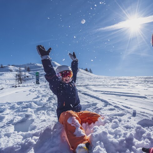 Mother and daughter play in the powder snow by sunshine. | © Davos Klosters Mountains