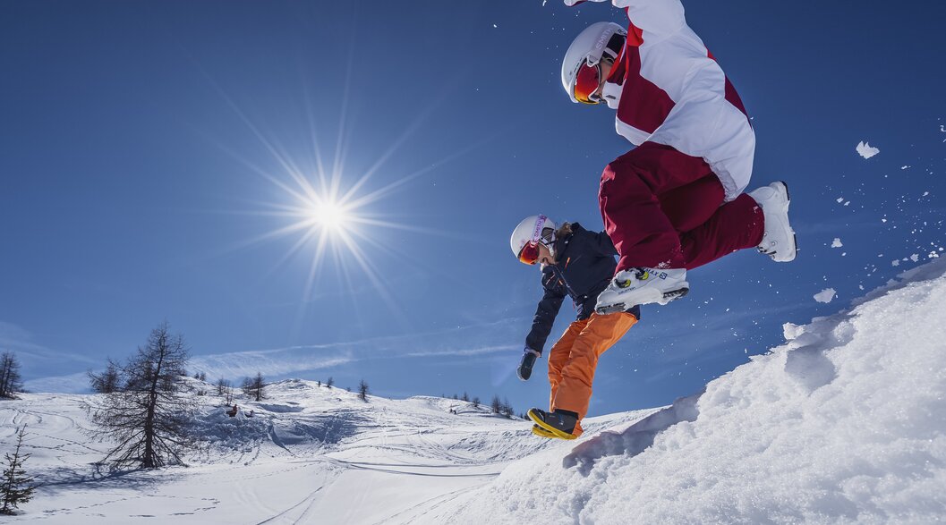 Spass am Rinerhorn | © Davos Klosters Mountains Kinder springen in den Schnee während dem die Sonne strahlt. | © Davos Klosters Mountains
