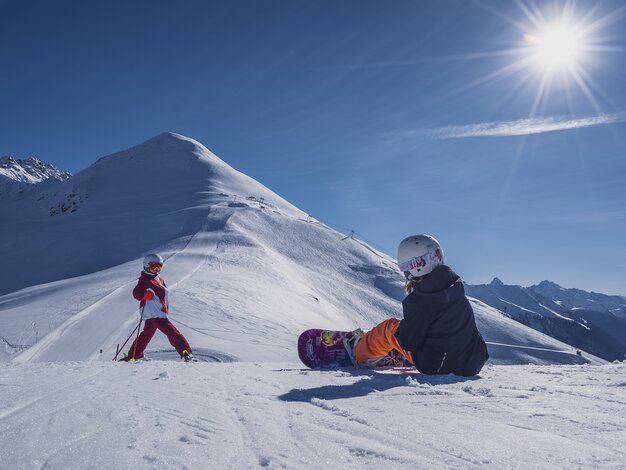 Mädchen wartet auf Ihre Schwester um die Piste hinunter zu sausen. | © Davos Klosters Mountains