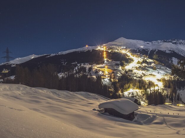 Beleuchtete Pisten und Schlittelbahn am Rinerhorn bei Nacht. | © Davos Klosters Mountains