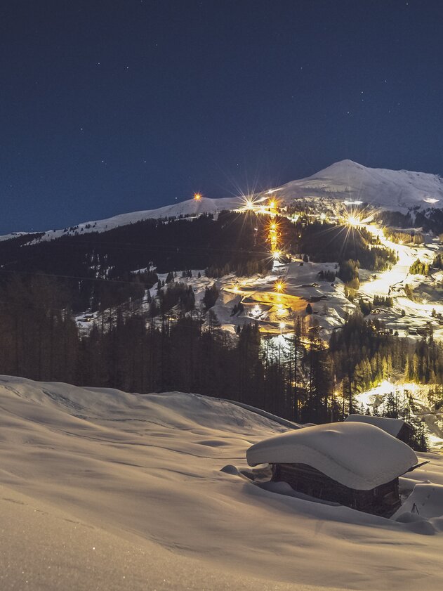 Illuminated slopes and sled run on the Rinerhorn by night. | © Davos Klosters Mountains