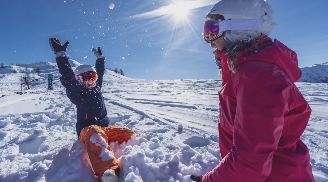 Mutter Tochter Zeit im Schnee | © Davos Klosters Mountains Mutter und Tochter spielen im Tiefschnee bei Sonnenschein. | © Davos Klosters Mountains