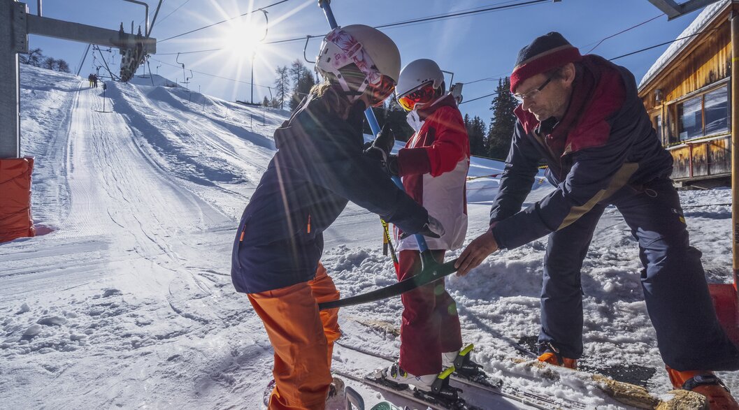 Kinder am Schlepplift | © Davos Klosters Mountains Angestellter der Bergbahnen Rinerhorn hilft Mädchen beim aufbügeln am Schlepplift. | © Davos Klosters Mountains
