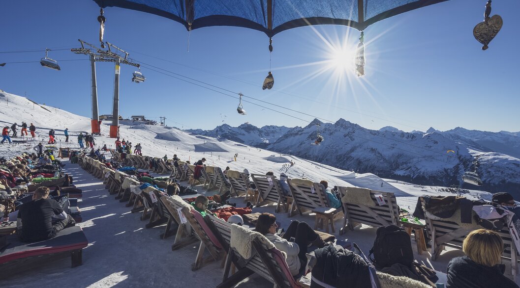 Gäste geniessen die Sonne in den Sonnenliegen im Chalet Güggel auf dem Jakobshorn. | © Davos Klosters Mountains