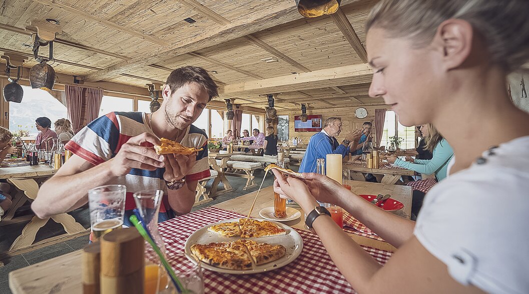 Ein Pärchen teilt sich eine Pizza nach dem Wandern auf Madrisa. | © Davos Klosters Mountains