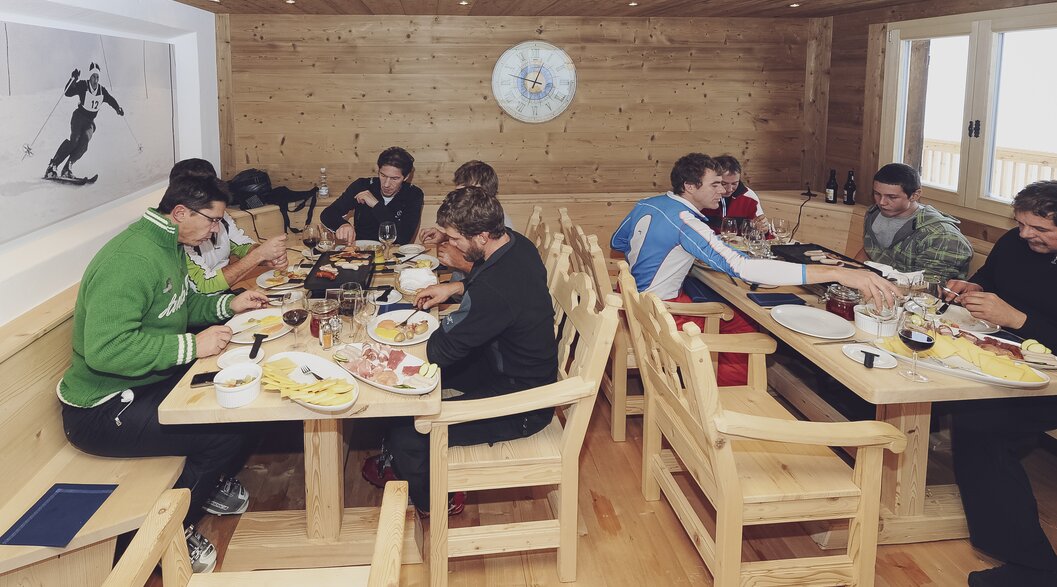 A group enjoys a raclette together in the Zügenhüttli Klosters. | © Davos Klosters Mountains