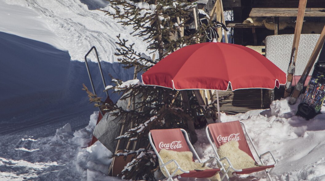 Two red sunbeds covered with fur including a red parasol are available for the guests. | © Davos Klosters Mountains