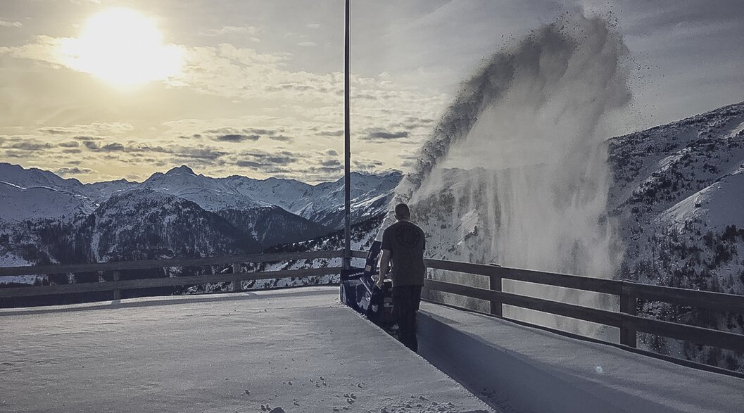 A man throws fresh snow from the terrace of Gruobenalp with a snow blower. | © Davos Klosters Mountains