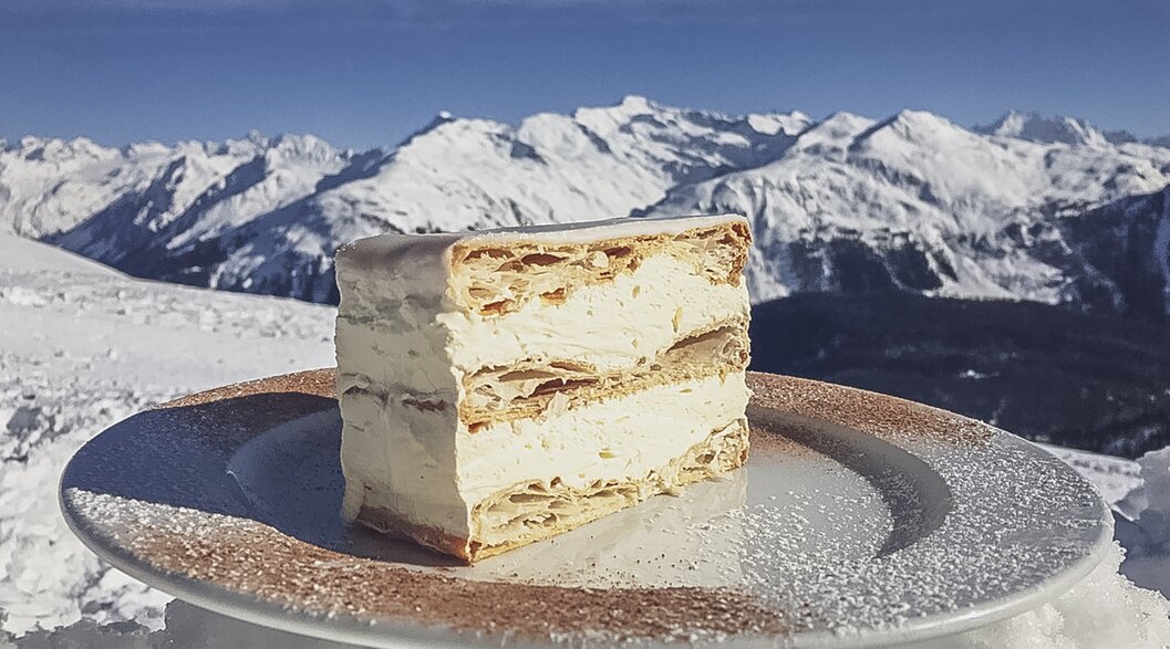 The legendary cream cake of Gruobenalp with a fantastic mountain panorama in the background. | © Davos Klosters Mountains