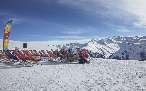 Rote Liegen stehen aufgereiht auf der Aussichtsterrasse der Gruobenalp. | © Davos Klosters Mountains