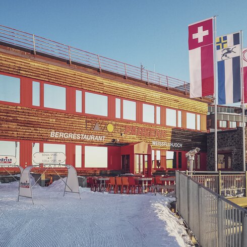 Aussenansicht auf das von der Sonne bescheinte Restaurant Weissfluhjoch auf Parsenn. | © Davos Klosters Mountains