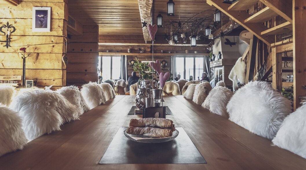 Long table, with a very special charm, is ready for the guests in the mountain restaurant Mäderbeiz Davos. | © Davos Klosters Mountains