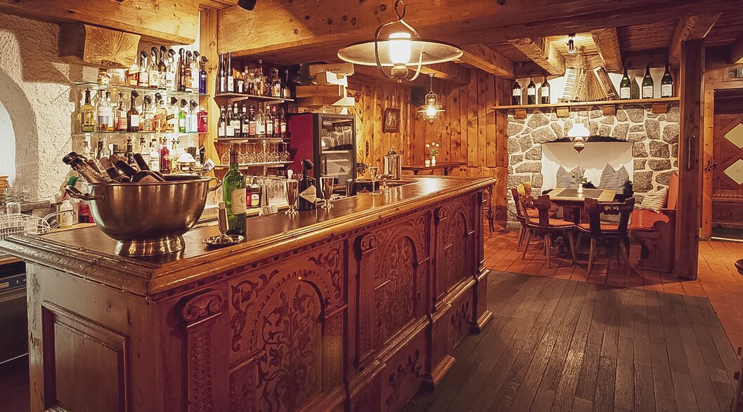 The traditional buffet with beautiful embossing in the wood and bottles on the top. | © Davos Klosters Mountains