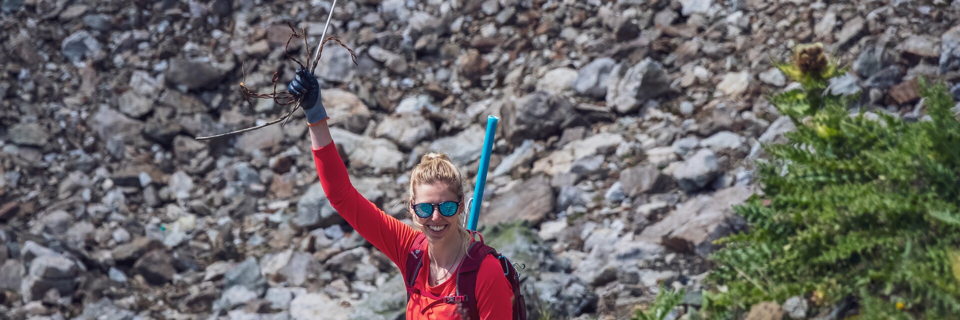 Erfolg gefundener Abfall | © Davos Klosters Mountains Eine rot gekleidete Helferin der Aufräumaktion auf Parsenn hält ihr gefundenen Abfall in die Luft. | © Davos Klosters Mountains