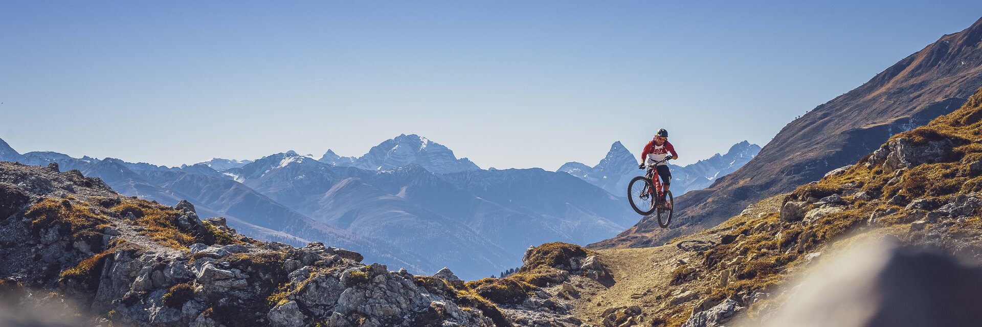 Biker Gotschna Signal Trail | © Davos Klosters Mountians Ein Biker macht einen Sprung auf dem Signaltrail auf Gotschna, das Tinzenhorn im Hintergrund. | © Davos Klosters Mountians