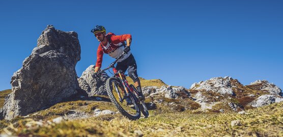 Ein Biker fährt im Herbst den Signal Trail in Richtung Klosters.