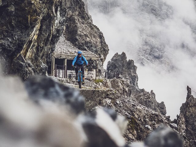 Ein Biker ganz in blau fährt den atemberaubenden Felsenweg auf Parsenn.  | © Davos Klosters Mountains