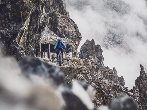 Ein Biker ganz in blau fährt den atemberaubenden Felsenweg auf Parsenn.  | © Davos Klosters Mountains