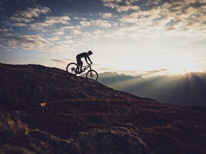 Der Biker fährt über den Grat auf Parsenn Gotschna und ist beim Abendlicht als Silhouette zu sehen. | © Davos Klosters Mountains