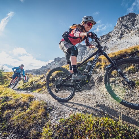 Eine Bikerin geniesst die rasante Abfahrt, ein Biker fährt hinterher. | © Davos Klosters Mountains