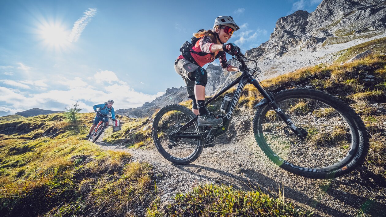 Eine Bikerin geniesst die rasante Abfahrt, ein Biker fährt hinterher. | © Davos Klosters Mountains