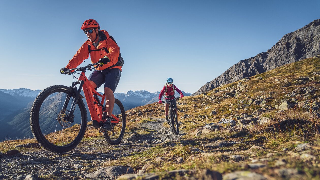 Ein Mann und eine Frau fahren mit dem E-Bike auf einem Singletrail in Davos Klosters. | © Davos Klosters Mountains