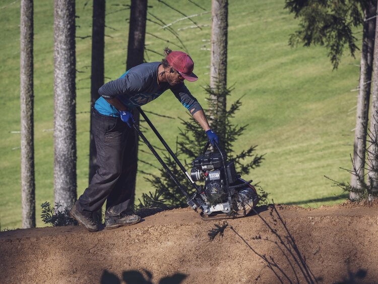Christoph Koch von der Trail Crew Davos befestigt mit einem Rüttelplatten-Verdichter die neue Strecke des Technik Trails. | © Davos Klosters Mountains 