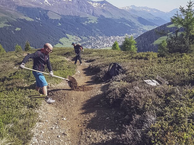 With shovels, two trail crew workers repair the path on Äbirugg.  | © Davos Klosters Mountains