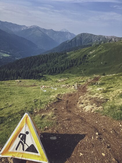 Ein Baustellenschild steht auf dem Bikeweg und zeigt, dass die Trail Crew bei der Arbeit ist.  | © Davos Klosters Mountains