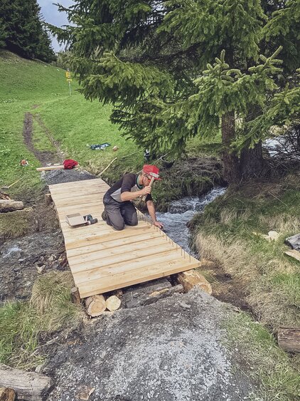 Die Trail Crew baut eine neue Holzbrücke, damit der Bach von Fussgängern und Bikern überquert werden kann. | © Davos Klosters Mountains