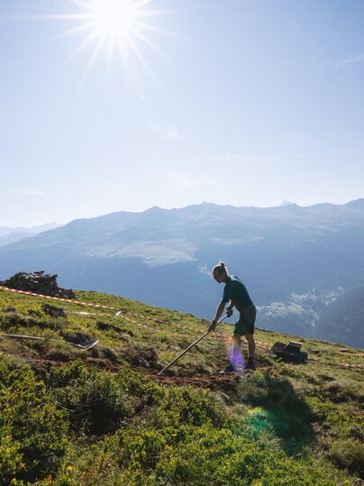 Person am Mülleinsammeln auf Wiese  | © Davos Klosters Mountains 