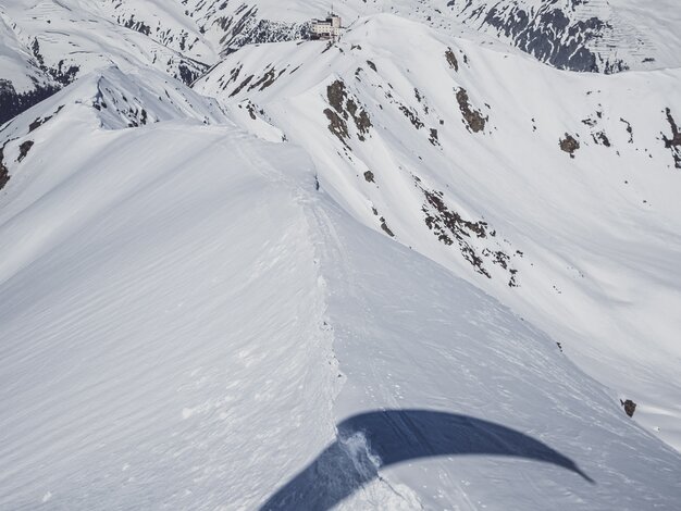 Der Schatten des Gleitschirms fällt auf den verschneiten Grat, der zum Jatzhorn und zum Jakobshorn führt.  | © Davos Klosters Mountains