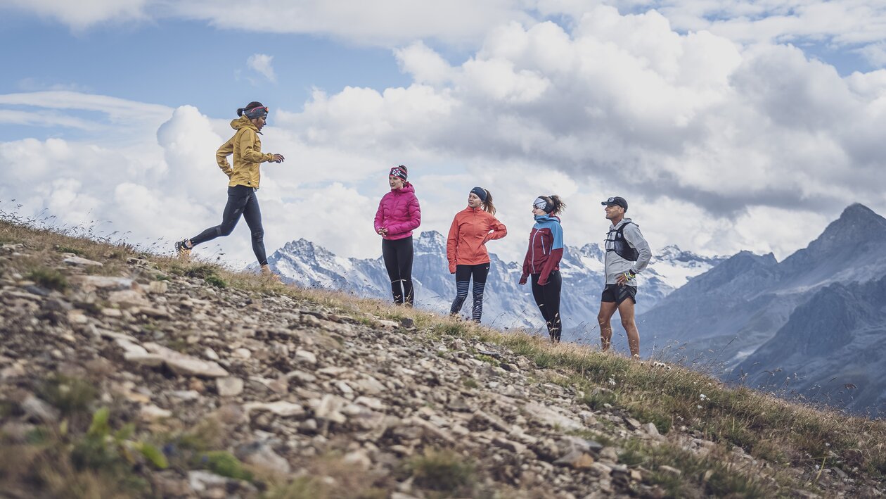 Die Trainerin zeigt die dynamische Lauftechnik für das bergab laufen vor, vier Läufer schauen zu.  | © Davos Klosters Mountains