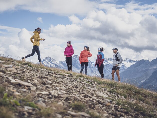 Die Trainerin zeigt die dynamische Lauftechnik für das bergab laufen vor, vier Läufer schauen zu.  | © Davos Klosters Mountains