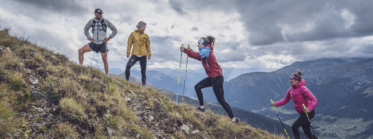 Auf dem 1K Jakobshorn üben zwei Läuferinnen das bergauf laufen mit Laufstöcken und werden von den beiden Coaches beobachten.  | © Davos Klosters Mountains