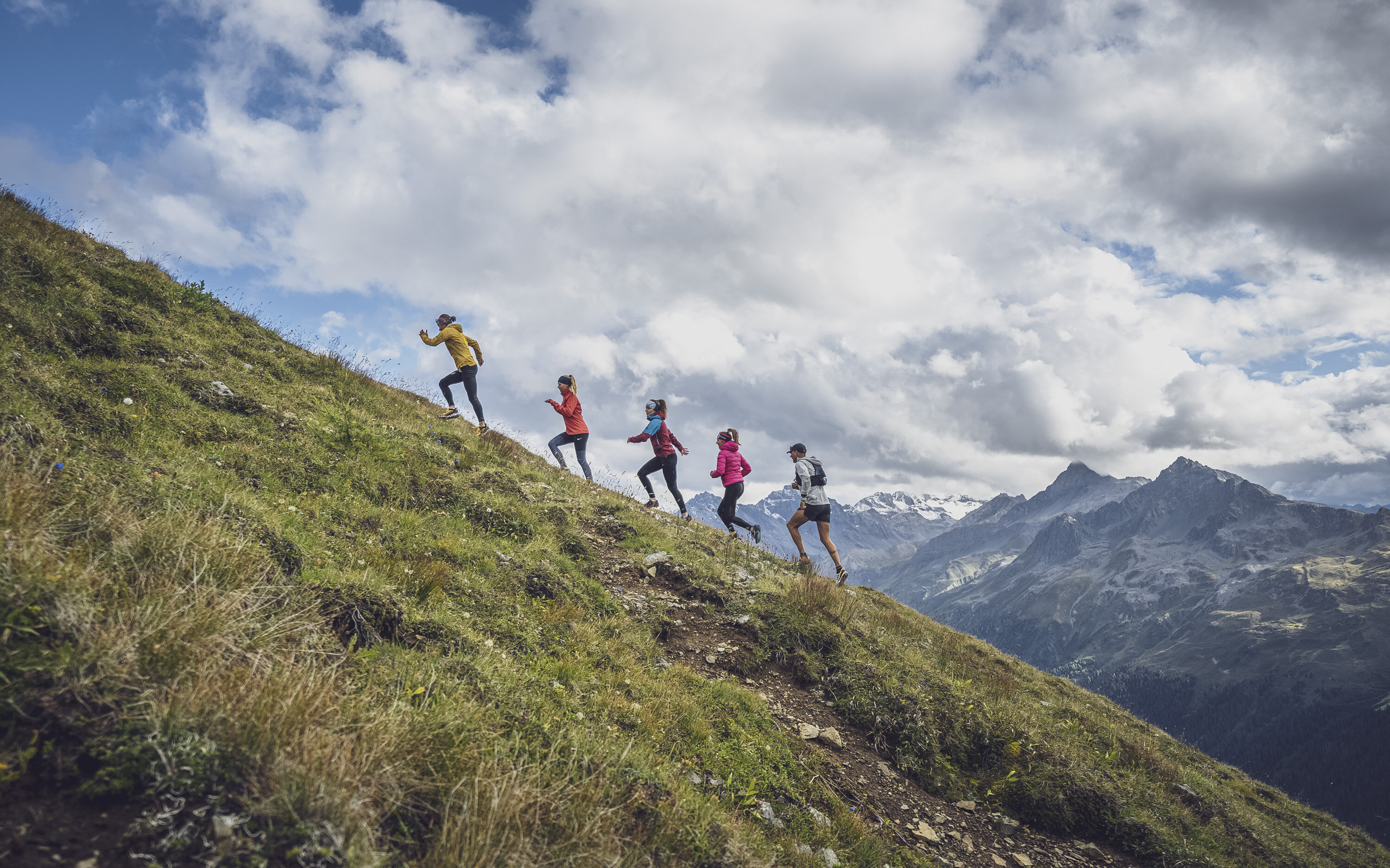 In einer Linie laufen die fünf Trailrunner den Hang des Jakobshorns hinauf.  | © Davos Klosters Mountains