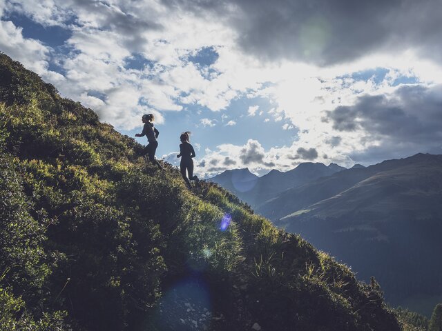 Bei Abendstimmung laufen zwei Trailrunnerinnen den Vertival Davos zum Jakobshorn hinauf.  | © Davos Klosters Mountains