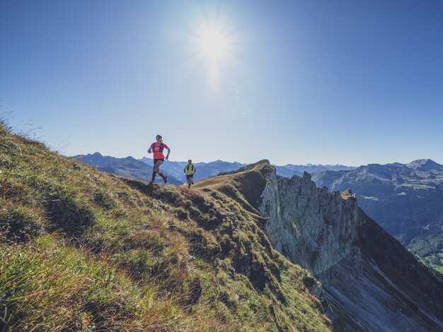 Ein Trailtrunner Paar rennt über den Grat des Geisshorns dahinter der Ausblick über das Prättigau.  | © Davos Klosters Mountains