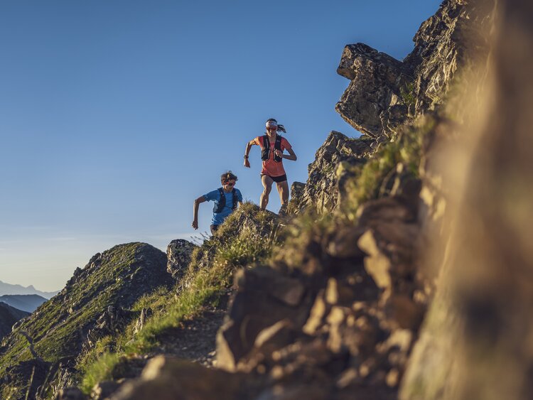 Trittsicher und mit viel Dynamik rennen zwei Trail Runner über den steinigen Grat in Richtung Jatzhorn.  | © Davos Klosters Mountains