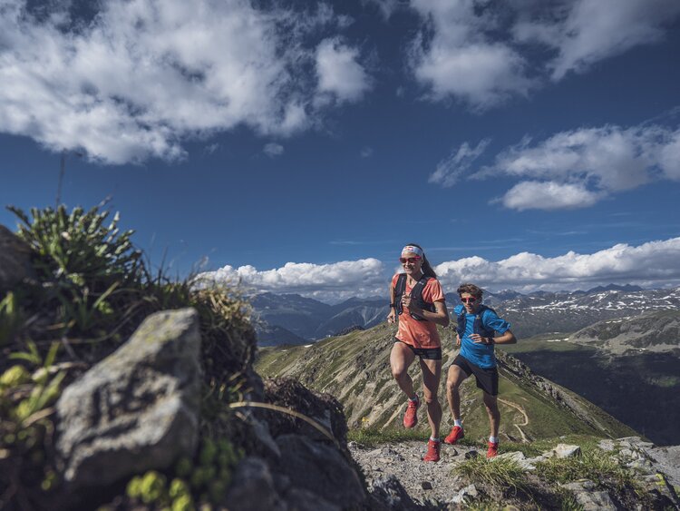 Zwei Trailrunner rennen auf dem steigenden Grat auf dem Jakobshorn in Richtung Sertig. | © Davos Klosters Mountains