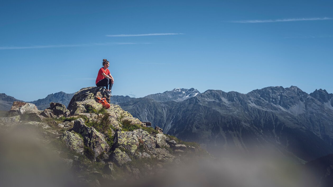 Person sitzend auf Felsen  | © Davos Klosters Mountains 
