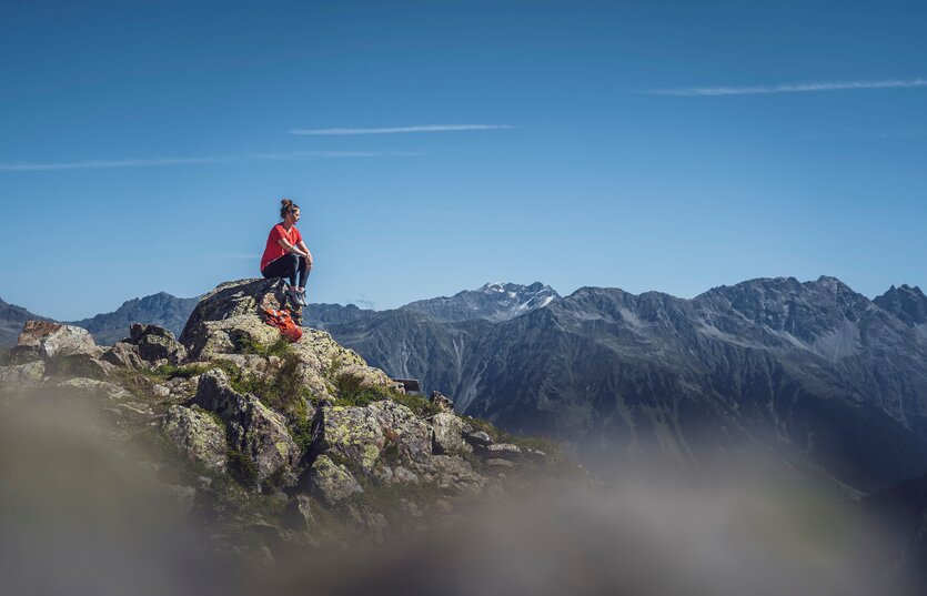Person sitzend auf Felsen  | © Davos Klosters Mountains 