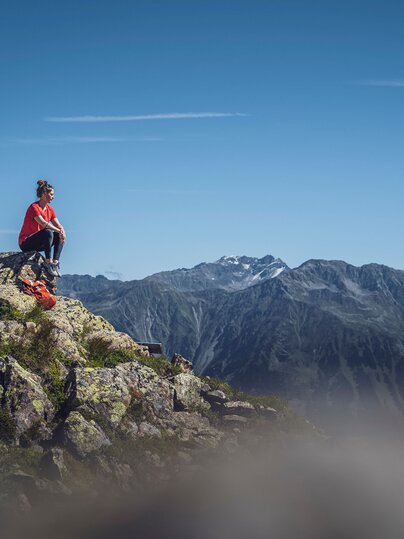 Person sitzend auf Felsen  | © Davos Klosters Mountains 