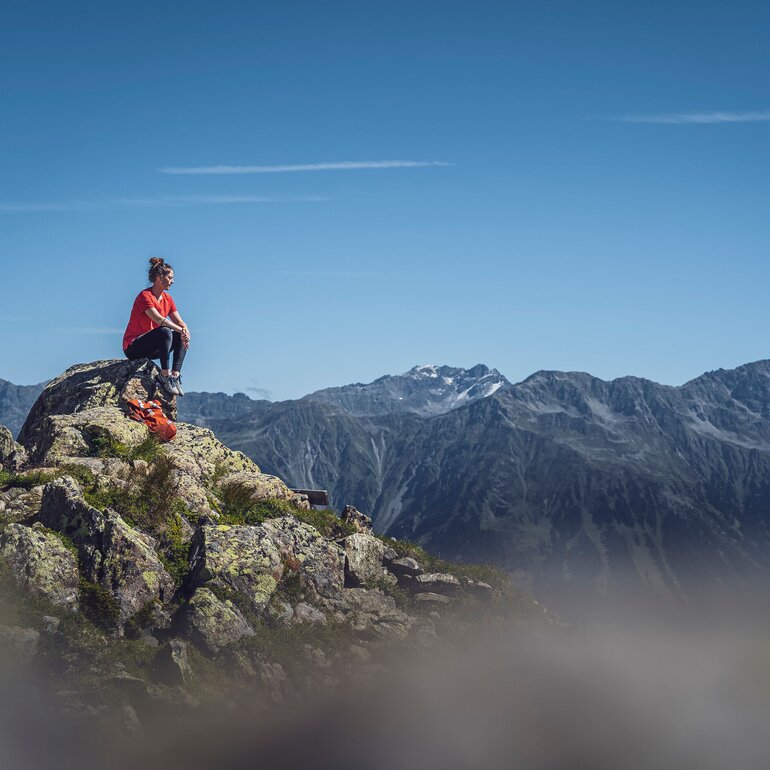 Person sitzend auf Felsen  | © Davos Klosters Mountains 