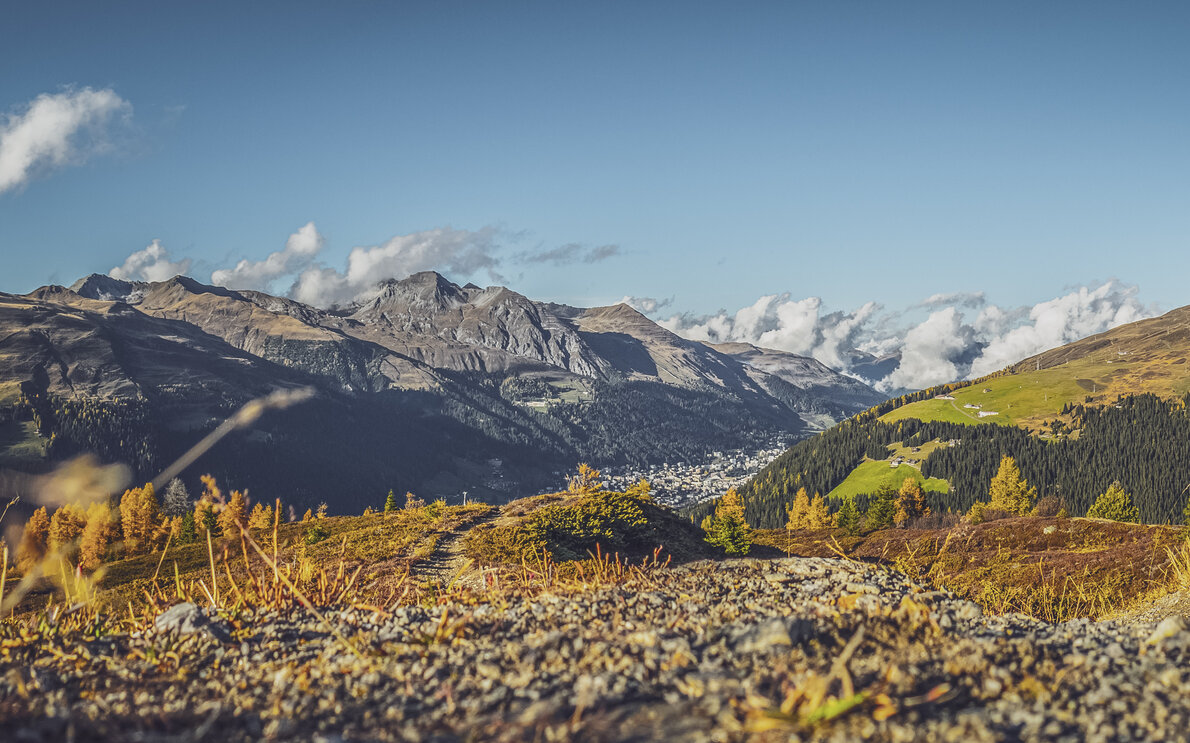 Blick vom Hubel auf dem Rinerhorn bis zur Ortschaft Davos mit herbstlicher Landschaft.  | © Davos Klosters Mountains