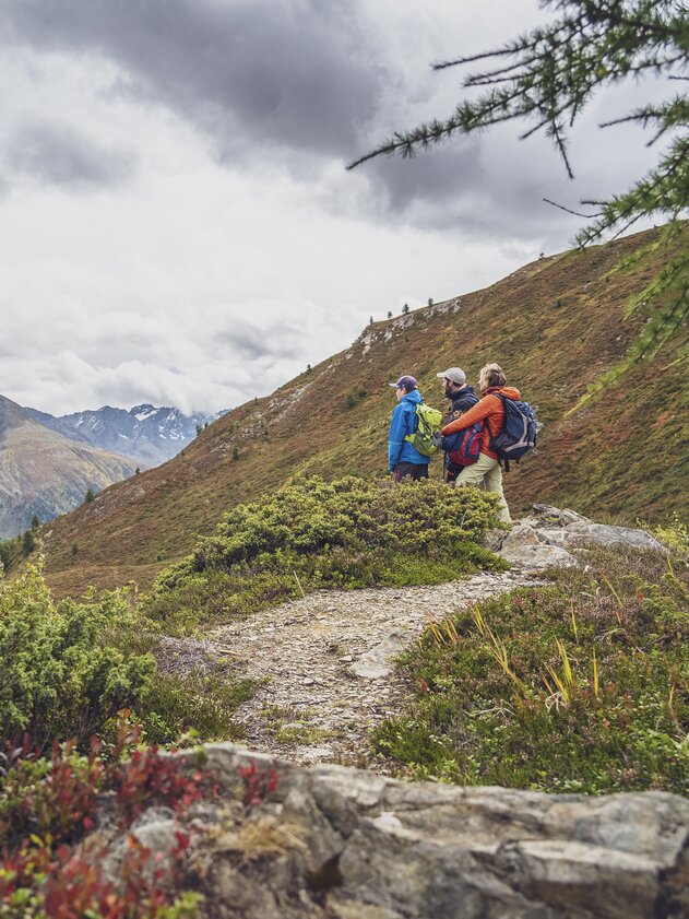 A family enjoys the view to the Sertig valley on their autumn hike on the Rinerhorn.  | © Davos Klosters Mountains