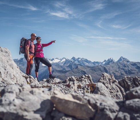 Zwei Wanderer stehen auf dem Weissfluhgipfel, die Frau zeigt auf den Horizont. | © Davos Klosters Mountains