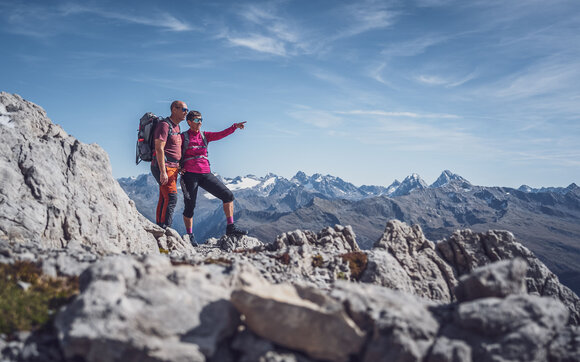 Zwei Wanderer stehen auf dem Weissfluhgipfel, die Frau zeigt auf den Horizont. | © Davos Klosters Mountains